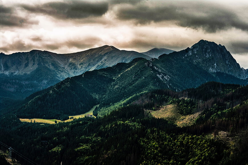 Dramatic Mountain Landscape with Cloudy Sky and Forested Valleys