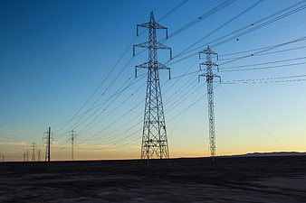 High Voltage Power Lines Silhouette Against Sunset Sky