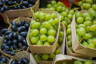 Fresh green and purple grapes in paper boxes
