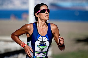 Female Triathlete Running on Beach in Blue Suit