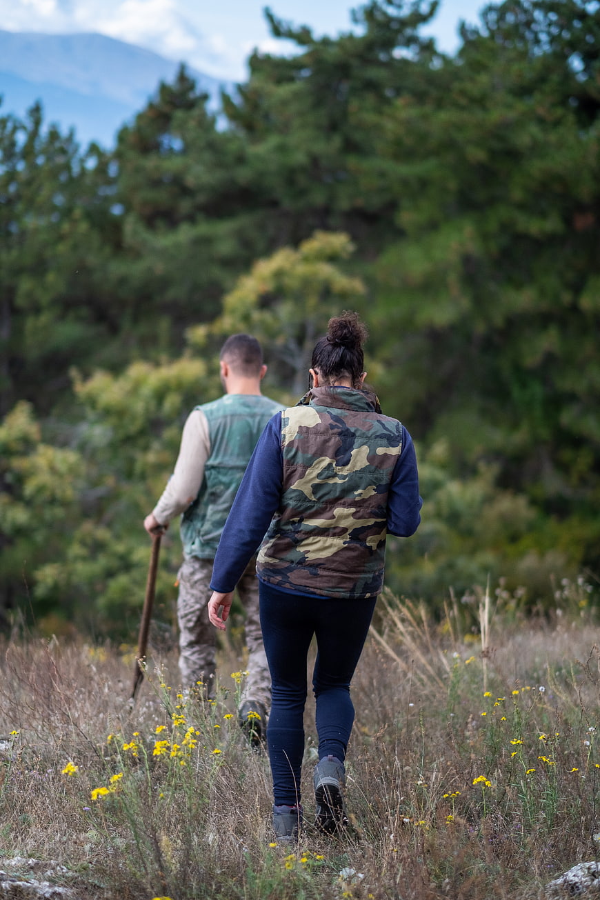 Couple Hiking Through Forest Field