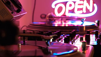 DJ Turntables and Neon Open Sign in Pink Light