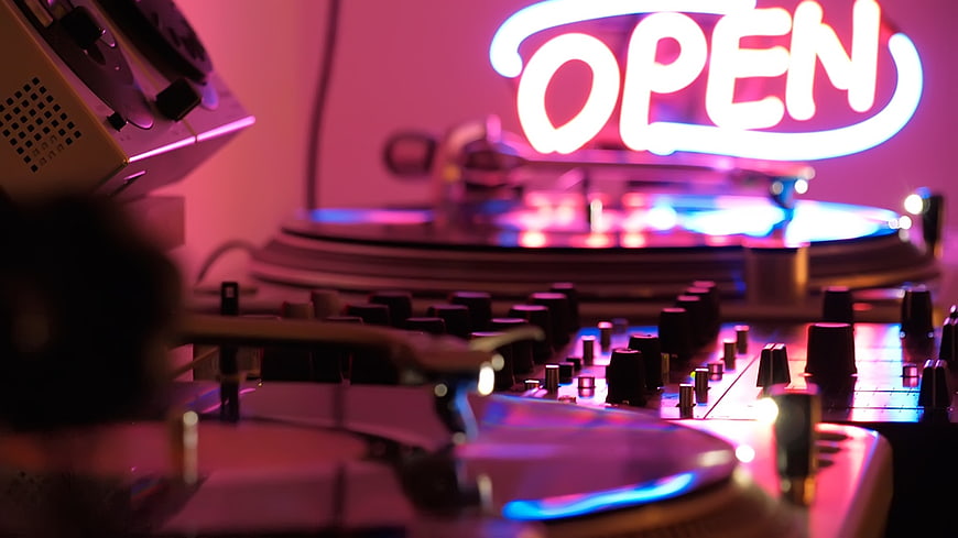 DJ Turntables and Neon Open Sign in Pink Light