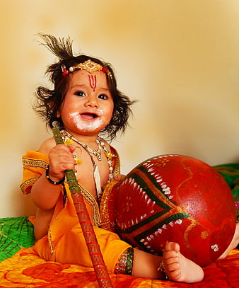 Baby dressed as Lord Krishna with peacock feather and butter pot