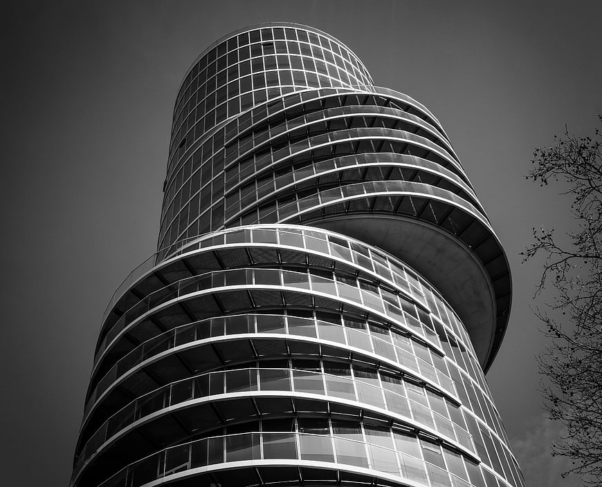 Low angle black and white modern curved glass skyscraper