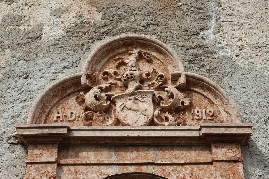 Historic Stone Coat of Arms with 1912 Date on Weathered Wall