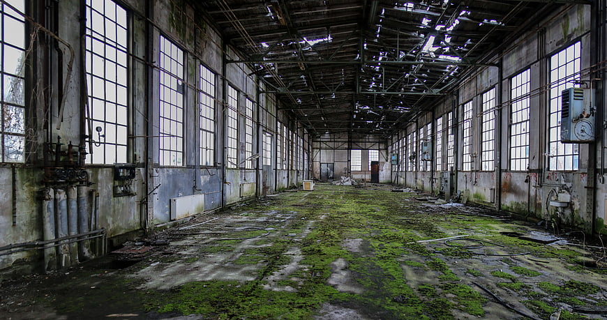 Abandoned Factory Interior with Mossy Floor and Broken Roof