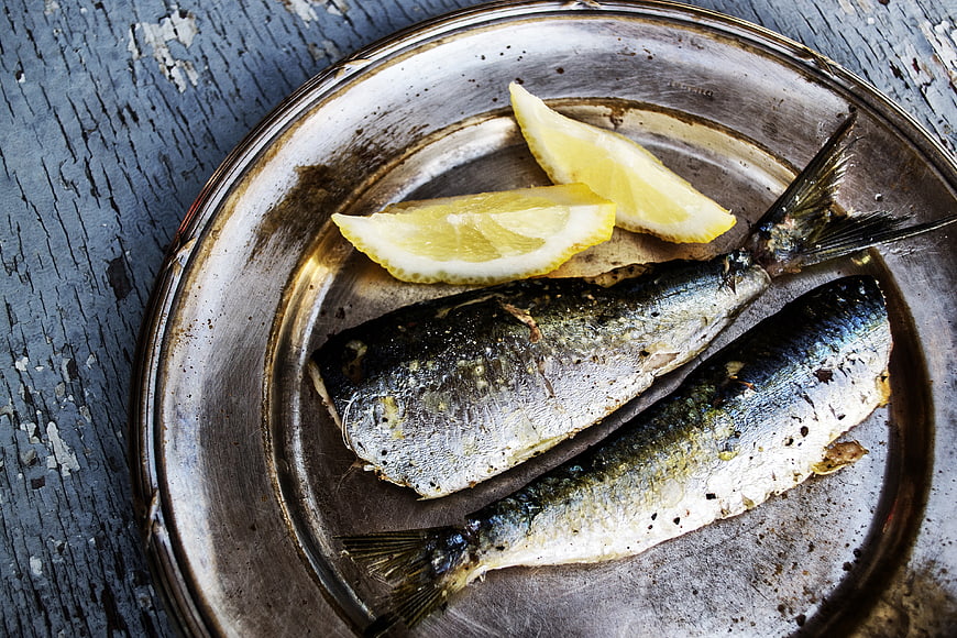 Grilled Sardines with Lemon on Rustic Metal Plate