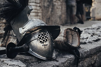 Ancient Roman Gladiator Helmet and Sword on Stone