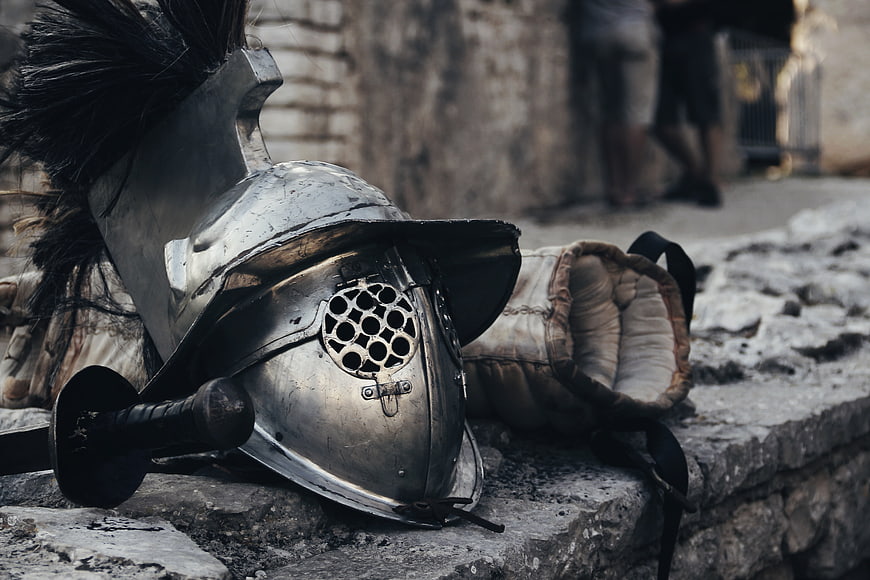 Ancient Roman Gladiator Helmet and Sword on Stone