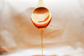 Golden Honey Dripping from Wooden Spoon