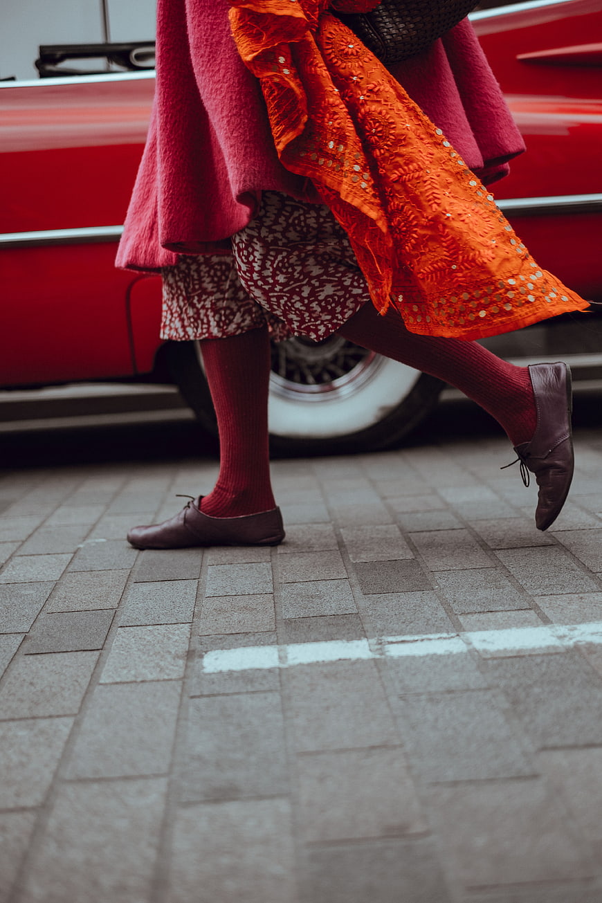 Woman Walking Past Vintage Red Car in Street Style