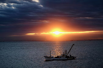 Fishing boat silhouette on Tokyo Bay during dramatic orange sunrise