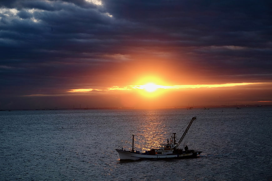 Fishing boat silhouette on Tokyo Bay during dramatic orange sunrise