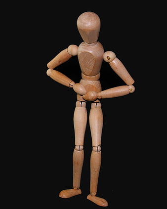 Wooden artist mannequin standing with hands on hips