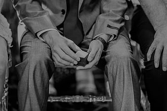 Groom holding wedding ring box in black and white