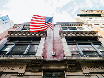 American flag waving on historic brick building facade