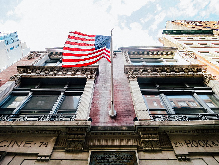 American flag waving on historic brick building facade