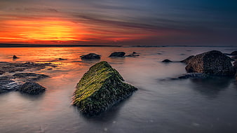 Long Exposure Sunset Over Mossy Rocks and Smooth Ocean Water