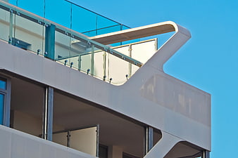 Modern White Building with Curved Balcony and Glass Railing