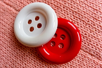 White and red four-hole buttons on pink knitted fabric