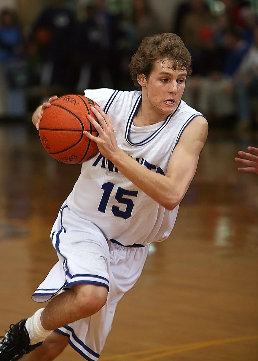 High School Basketball Player Dribbling on Court