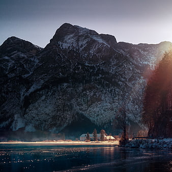 Snowy Mountain Landscape with Lake and Cabin at Sunset