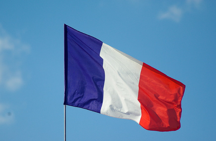 French flag waving against a clear blue sky