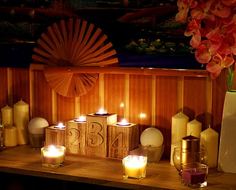 Candlelit wooden number blocks and spa decor on a shelf