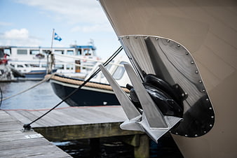 Close-up of stainless steel boat anchor at wooden dock