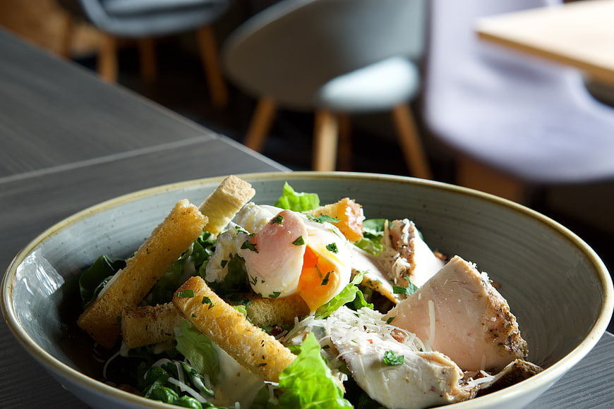 Close-up of Caesar salad with chicken and poached egg