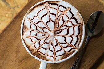 Top View Cappuccino with Intricate Latte Art on Wooden Table