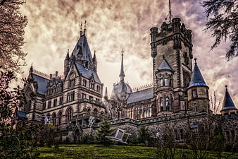 Gothic castle with floating chairs and dramatic sky
