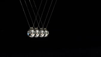 Newton's Cradle Physics Pendulum Balls Against Black Background