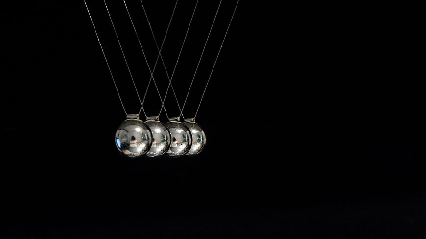 Newton's Cradle Physics Pendulum Balls Against Black Background
