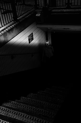 Woman in Sunglasses Walking Down Dark Subway Stairs