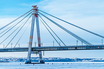 Cable-stayed bridge over frozen river in winter