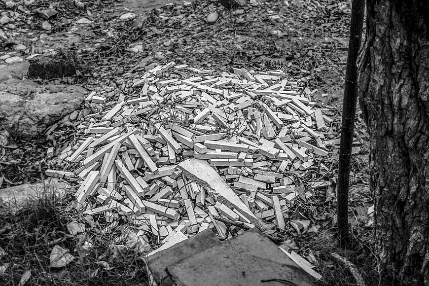 Pile of broken bricks and rubble on forest ground