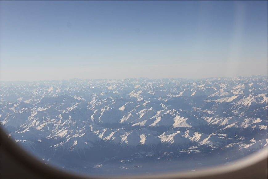 Aerial View of Snow-Covered Mountain Range from Airplane Window
