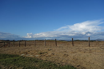 Rural landscape with wooden fence and blue sky