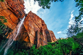 Waterfall cascading down red rock cliff in national park