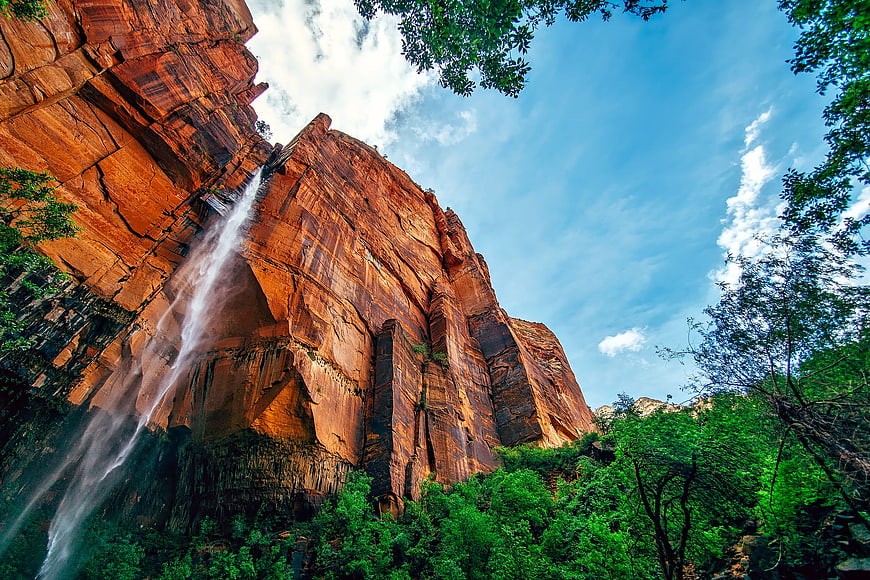 Waterfall cascading down red rock cliff in national park