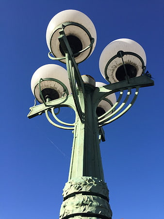 Low angle view of vintage Art Nouveau street lamp against blue sky
