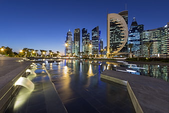 Doha Cityscape at Dusk with Water Reflections and Modern Skyscrapers