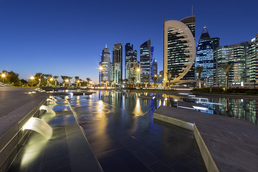 Doha Cityscape at Dusk with Water Reflections and Modern Skyscrapers