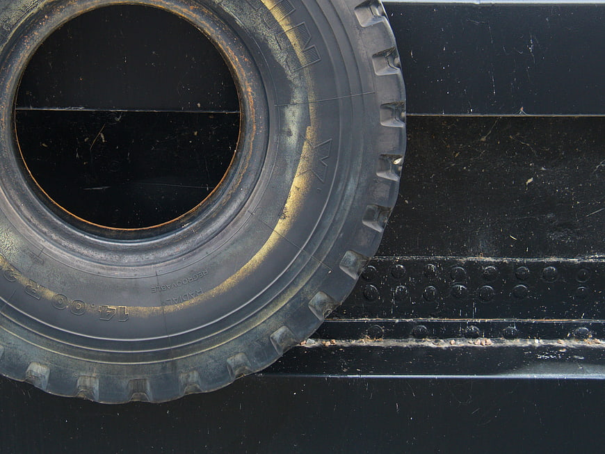 Close-up of worn black truck tire on metal surface