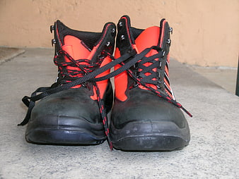Black and Orange Safety Boots on Concrete Surface