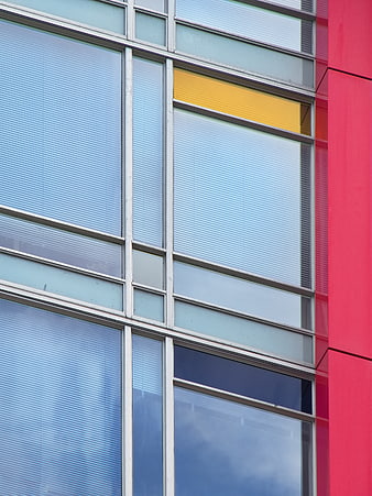 Modern building facade with blue glass windows and red wall