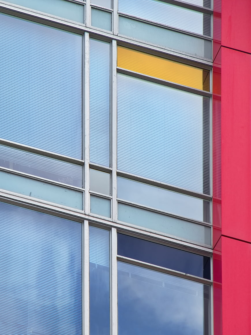Modern building facade with blue glass windows and red wall
