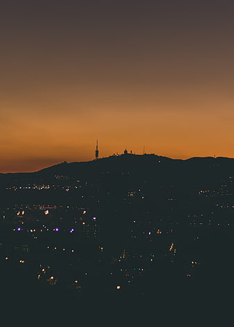 Silhouette of Barcelona skyline at sunset with city lights